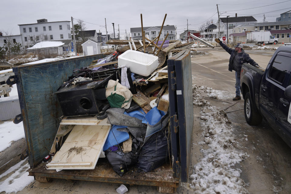 FILE - Property manager Brent Akmon dumps debris from waterfront property he has been repairing following a devastating storms, Wednesday, Jan. 31, 2024, in the Camp Ellis section of Saco, Maine. (AP Photo/Robert F. Bukaty)