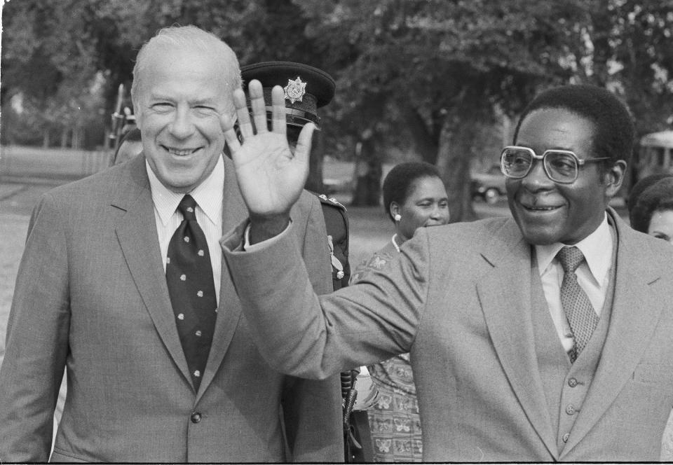 FILE - In this Sept. 12, 1983, file photo, Secretary of State George Shultz, left, and Prime Minister of Zimbabwe, Robert G. Mugabe, walk to a car after Mugabe was greeted by Shultz on his arrival to Washington for talks. Mugabe, the longtime leader of Zimbabwe who was forced to resign in 2017 after a military takeover, has died at 95. (AP Photo/Bob Daugherty, file)