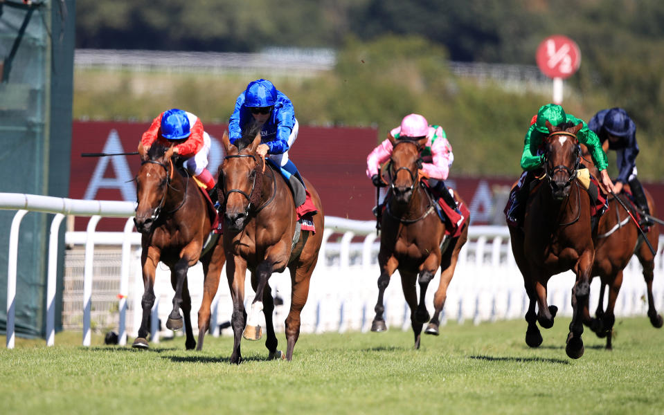 Wild Illusion and William Buick (blue) on their way to winning the Nassau Stakes at Goodwood