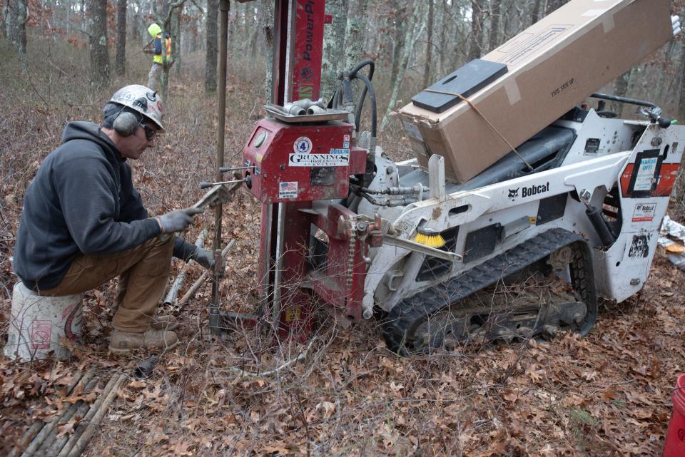 Dan Bronson, with Bronson Drilling, sends down piping for a test well in the woods off Mary Dunn Road, about a half mile east of the fire training academy.