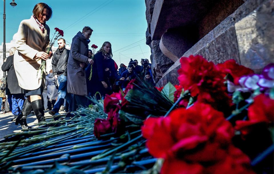 People lay flowers during a commemoration for the victims of the 2017 metro bomb attack in Saint Petersburg on April 3, 2019.  The bomb went off on a train in the city's metro, killing 15 people and injuring almost 70 others.