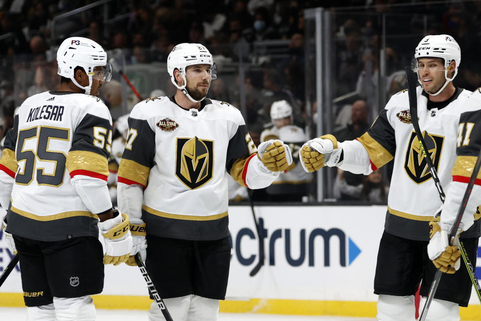 Vegas Golden Knights defenseman Shea Theodore, center, celebrates his goal against the Los Angeles Kings during the first period of an NHL hockey game Thursday, Oct. 14, 2021, in Los Angeles. (AP Photo/Ringo H.W. Chiu)