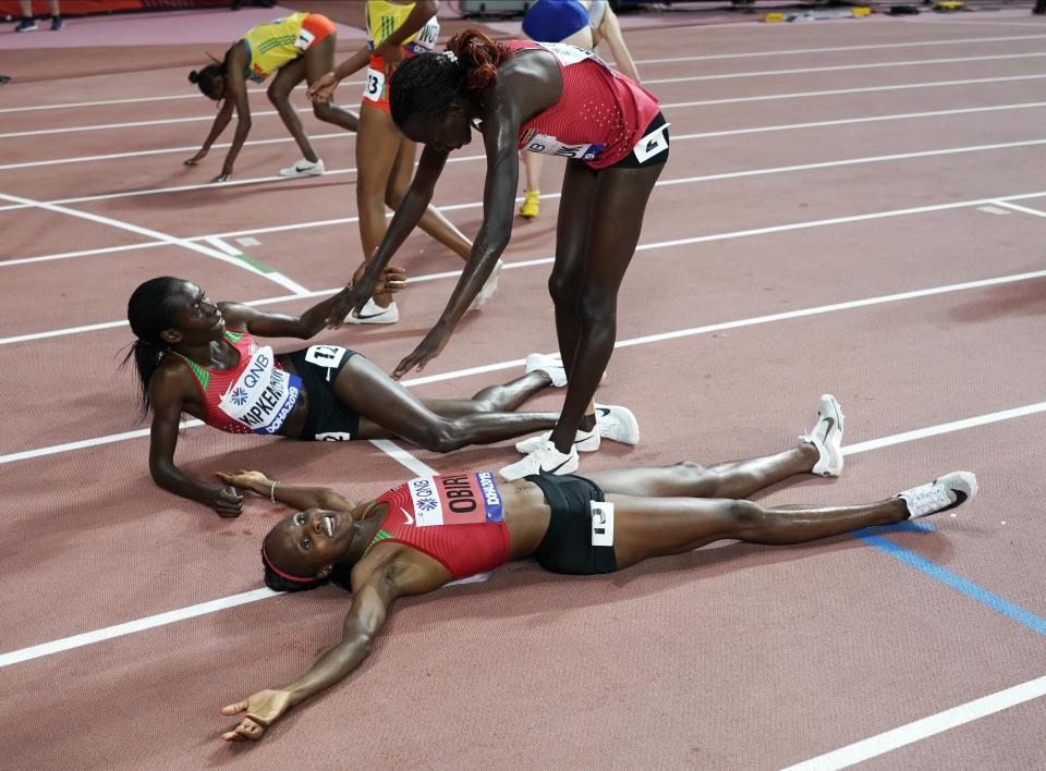 Hellen Obiri, foreground, of Kenya celebrates after winning the gold medal in the women's 5000 meter final at the World Athletics Championships in Doha, Qatar, Saturday, Oct. 5, 2019. (AP Photo/David J. Phillip)