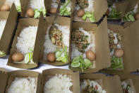 "Pad krapow gai", the spicy minced chicken is filled in a box by chef Tim Butler from the U.S. a volunteer of COVID Thailand Aid, for the railway-side community at Bo.lan restaurant in Bangkok, Thailand Wednesday, June 10, 2020. Thailand's Natalie Bin Narkprasert, who runs a business in Paris, was stranded in her homeland by a flight ban, so she decided to use her skills to organize a network of volunteers, including Michelin-starred chefs, to help those in her homeland whose incomes were most affected by the pandemic restrictions. (AP Photo/Sakchai Lalit)