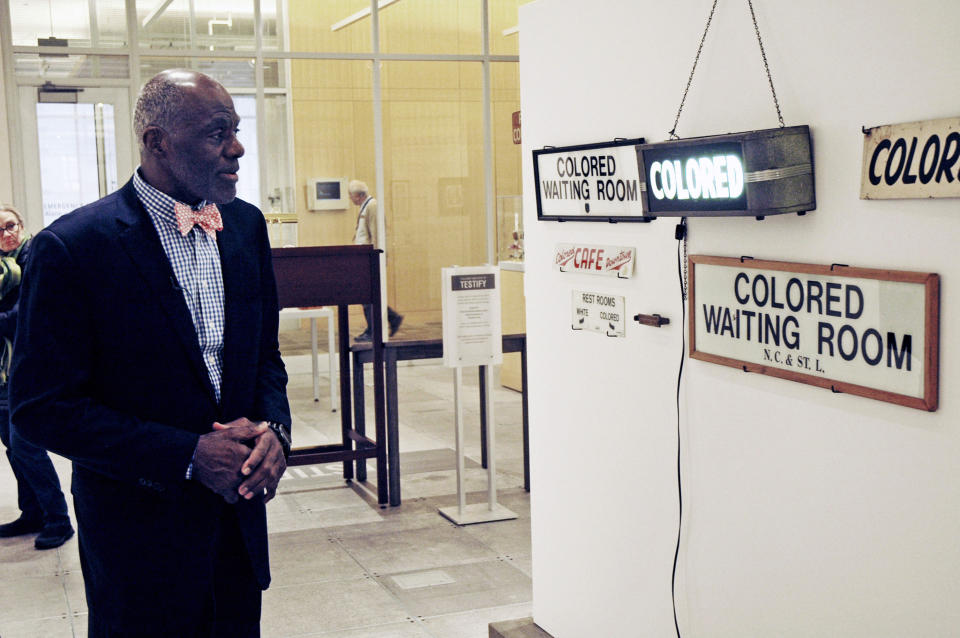 File-In this Jan. 11, 2018 file photo, Alan Page, NFL Hall of Famer and retired Minnesota Supreme Court justice, looks at a display which is among the artifacts of slavery and segregation collected by Page and his wife, Diane Sims Page. Page has counted art collection among his many life pursuits, and the former Vikings star has two of his prized pieces up for sale through a New York auction house, each valued at more than $200,000. (AP Photo/Steve Karnowski, File)