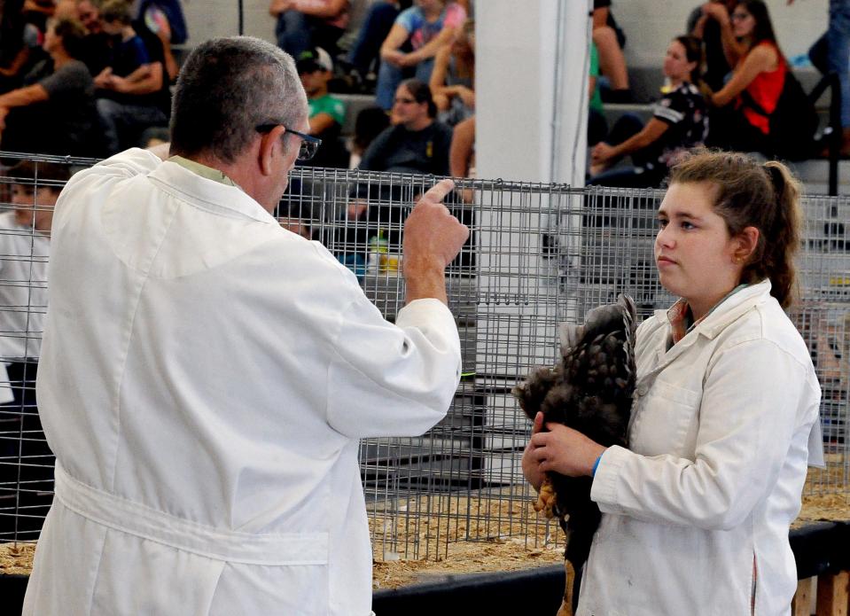 Jayley Steen listens to her judge in the poultry show judging at the Wayne County Fair.