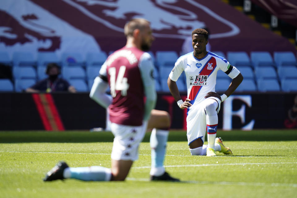 Crystal Palace's Wilfried Zaha takes a knee in support of the Black Lives Matter movement before the English Premier League soccer match between Aston Villa and Crystal Palace at Villa Park in Birmingham, England, Sunday, July 12, 2020. (Tim Keeton/Pool Photo via AP)