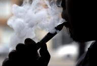 Daryl Cura demonstrates an e-cigarette at Vape store in Chicago, Wednesday, April 23, 2014. The federal government wants to ban sales of electronic cigarettes to minors and require approval for new products and health warning labels under regulations being proposed by the Food and Drug Administration. (AP Photo/Nam Y. Huh)