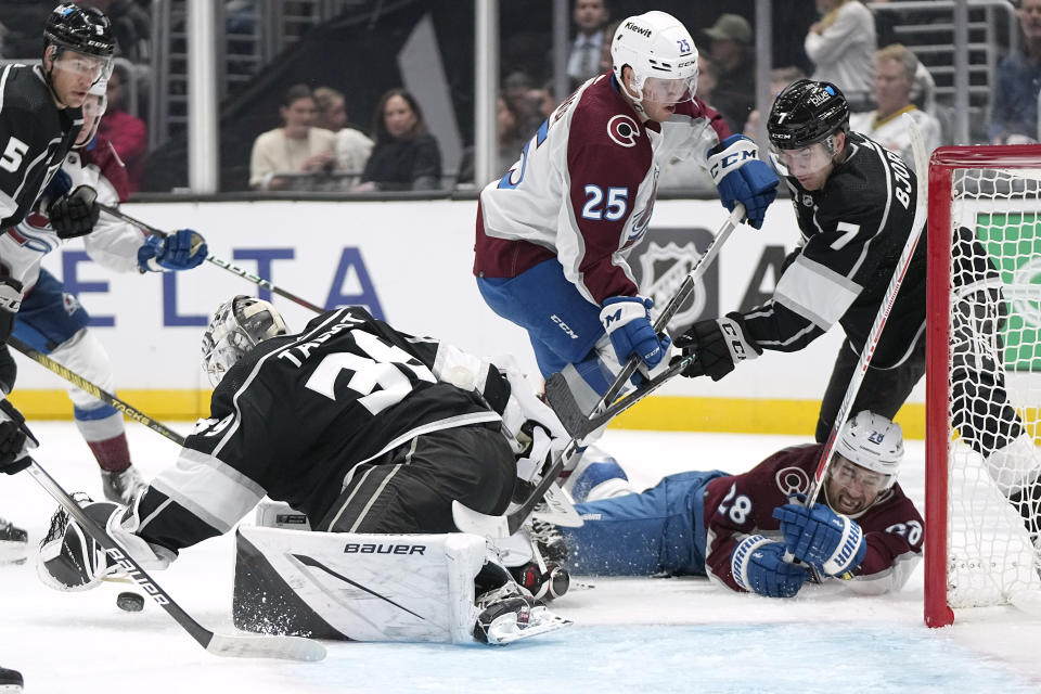 Los Angeles Kings goaltender Cam Talbot, left, stops a shot as Colorado Avalanche left wing Miles Wood, lower right, falls and right wing Logan O'Connor, third from right, battles with defenseman Tobias Bjornfot during the third period of an NHL hockey game Wednesday, Oct. 11, 2023, in Los Angeles. (AP Photo/Mark J. Terrill)