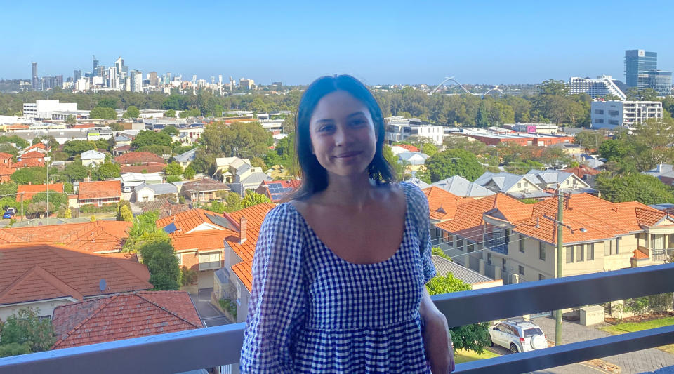 Home buyer standing on her balcony in front of her Perth city views.