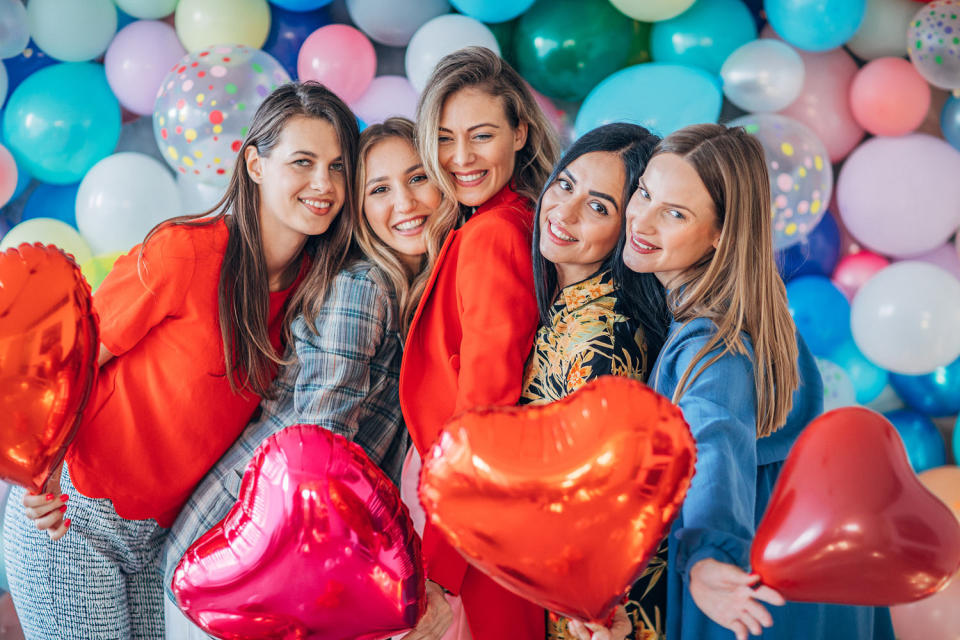 Group of young women with heart balloons. (Getty Images)