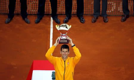 Novak Djokovic of Serbia holds up his trophy after winning the final tennis match against Tomas Berdych of the Czech Republic at the Monte Carlo Masters in Monaco April 19, 2015. REUTERS/Eric Gaillard - RTR4XX9R