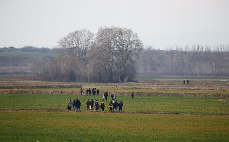 A group of migrants walk through the Turkish-Greek border in a village near the border city of Edirne