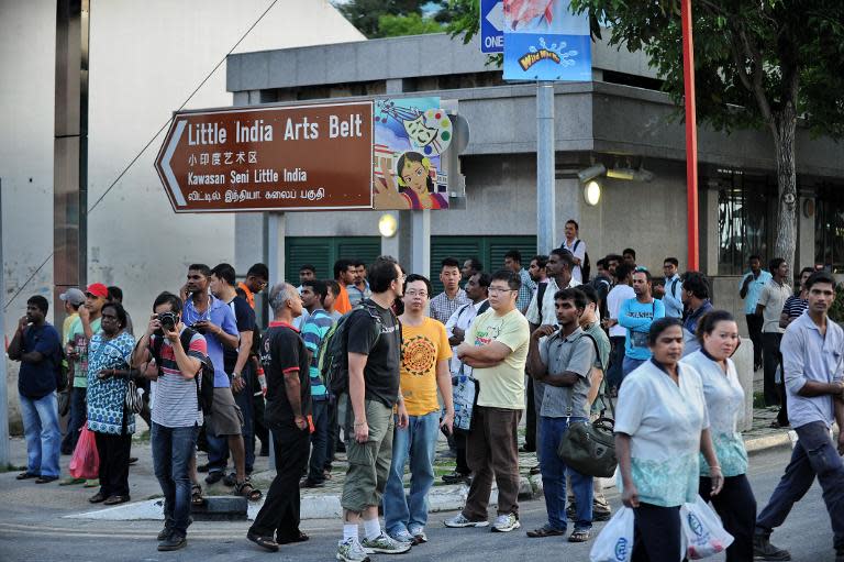 Bystanders gather on the corner of a street in Little India, following a riot the day before by South Asian workers, in the worst outbreak of violence in more than 40 years in the tightly controlled city-state, on December 9, 2013