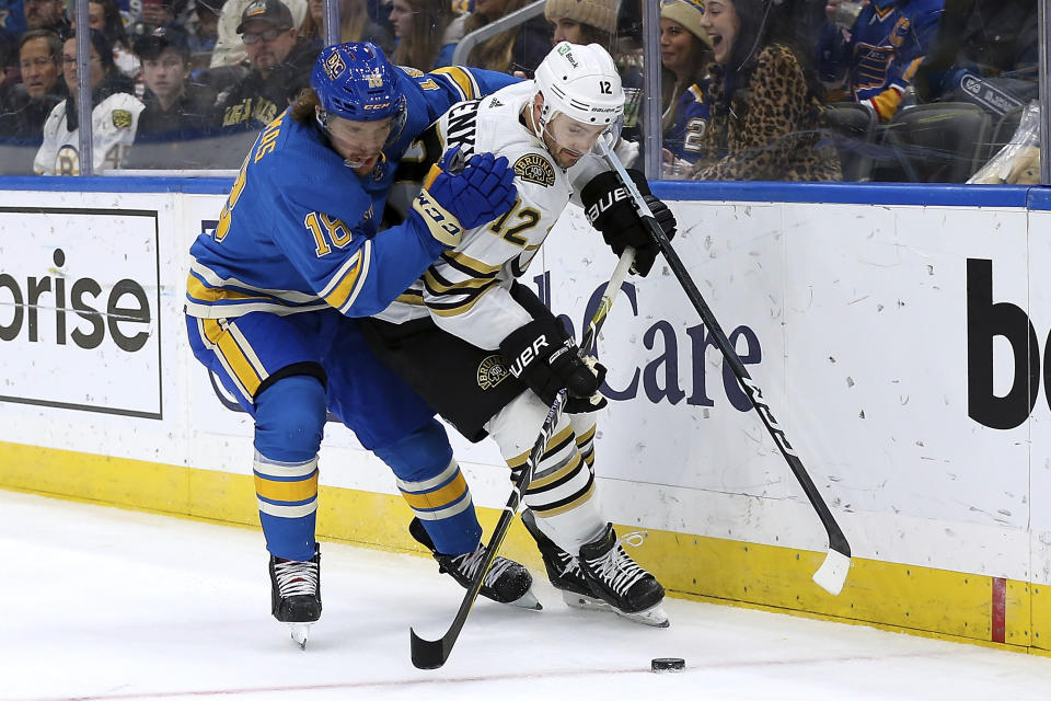 St. Louis Blues' Robert Thomas (18) and Boston Bruins' Kevin Shattenkirk (12) vie for control of the puck during the second period of an NHL hockey game Saturday, Jan. 13, 2023, in St. Louis. (AP Photo/Scott Kane)