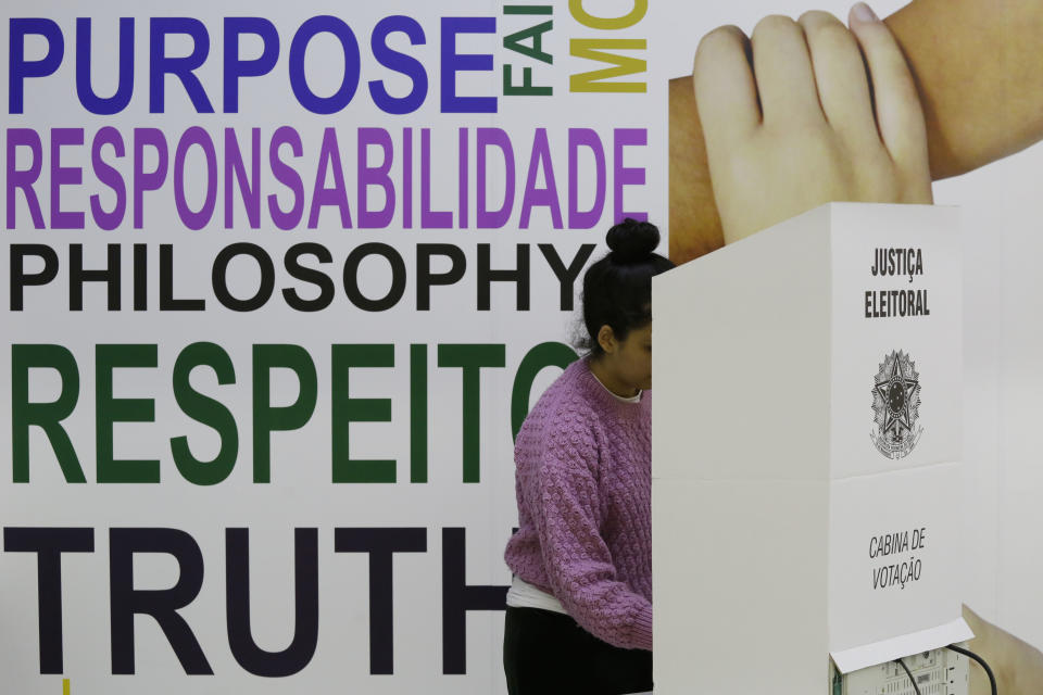 A woman casts her vote in the general elections in Sao Paulo, Brazil, Sunday, Oct. 7, 2018. Brazilians have started trickling to voting booths to choose leaders in an election marked by intense anger at the ruling class following years of political and economic turmoil. (AP Photo/Nelson Antoine)