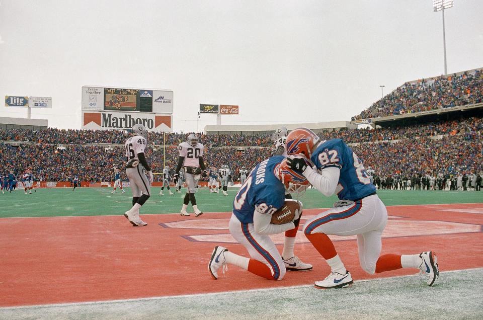 Buffalo Bills' receiver Bill Brooks (80) is congratulated by teammate Don Beebe (82) after Brooks scored on a pass play from Bills Quarterback Jim Kelly in the third quarter against the Los Angeles Raiders, Saturday, Jan. 15, 1994, in Orchard Park, N.Y. Brooks scored two Bills touchdowns in their 29-23 win over the Raiders.