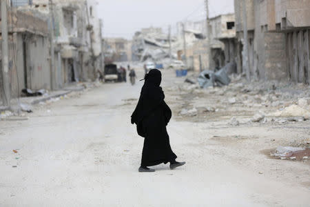 A woman walks through a damaged neighbourhood in the northern Syrian town of al-Bab, Syria March 4, 2017. REUTERS/Khalil Ashawi