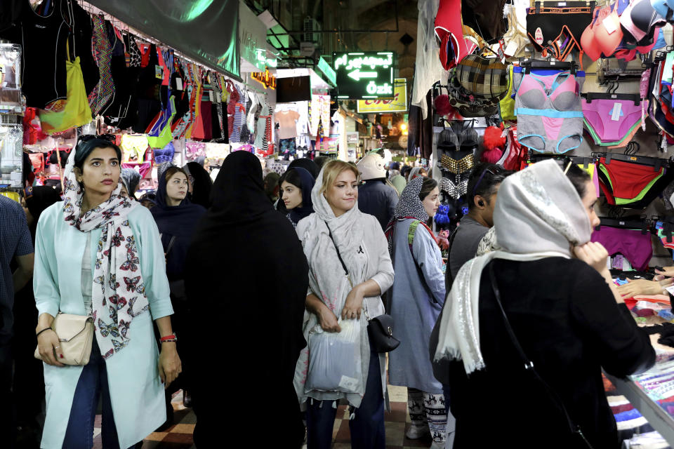 People shop at the old main bazaar in Tehran, Iran, Tuesday, July 2, 2019. While opinions differ across Tehran's Grand Bazaar about the ongoing tensions between the U.S. and Iran over its unraveling nuclear deal, there's one thing those in the beating heart of Iran's capital city agree on: American sanctions hurt the average person, not those in charge. (AP Photo/Ebrahim Noroozi)