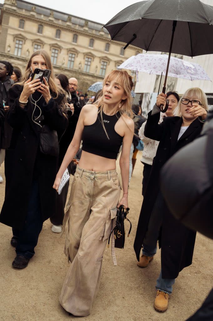 paris, france february 29 a guest wears beige wide pants, black cropped top and black bag outside off white during the womenswear fallwinter 20242025 as part of paris fashion week on february 29, 2024 in paris, france photo by raimonda kulikauskienegetty images