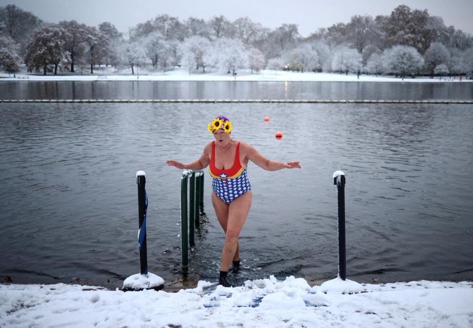 A swimmer dips her feet in Serpentine lake, as cold weather continues, in London (REUTERS)