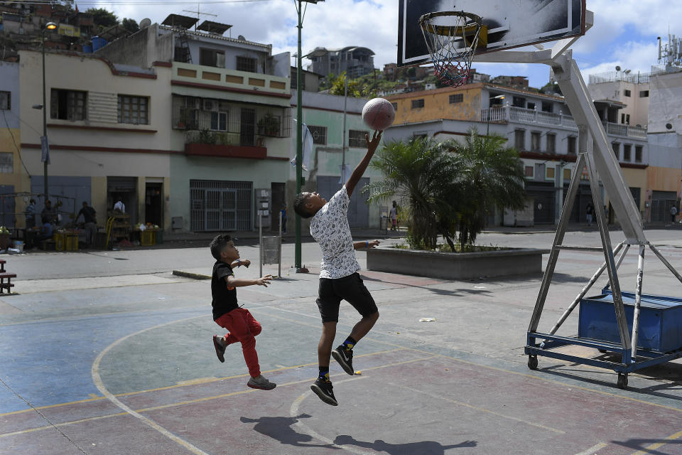 Children play a game of one on one on a public basketball court in the San Agustin neighborhood on Christmas Day in Caracas, Venezuela, Friday, Dec. 25, 2020, amid the new coronavirus pandemic. (AP Photo/Matias Delacroix)