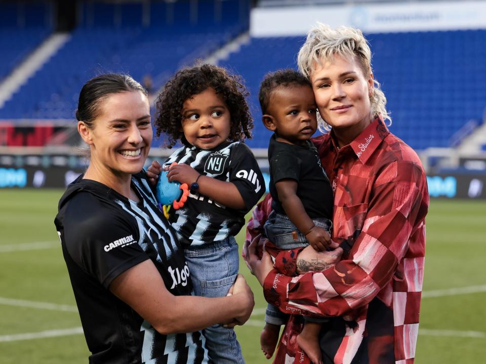 Ashlyn Harris (right) holds son Ocean as she poses for a photo with then-wife Ali Krieger (left) and daughter Sloane.