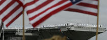 Sailors man the rails as the nuclear aircraft carrier Harry S. Truman approaches the pier at Naval Station Norfolk in Norfolk, Va., Friday, April 18, 2014. The Carrier Strike Group is returning form a 9-month deployment to the Middle East. (AP Photo/Steve Helber)