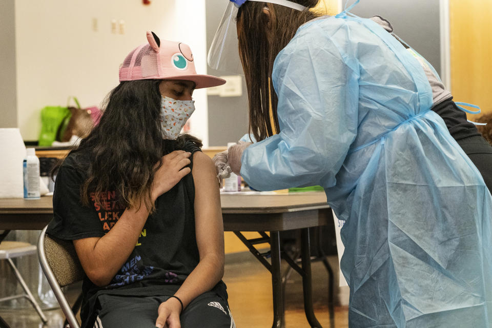 High school freshman Jeff Eseroma, 14, is vaccinated at a school-based COVID-19 vaccination clinic for students 12 and older in San Pedro, Calif., Monday, May 24, 2021. Schools are turning to mascots, prizes and contests to entice youth ages 12 and up to get vaccinated against the coronavirus before summer break. (AP Photo/Damian Dovarganes)