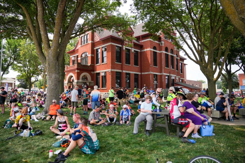 Riders take a rest in downtown Greenfield during Day 3 of RAGBRAI 2024 on Tuesday, July 23, 2024.