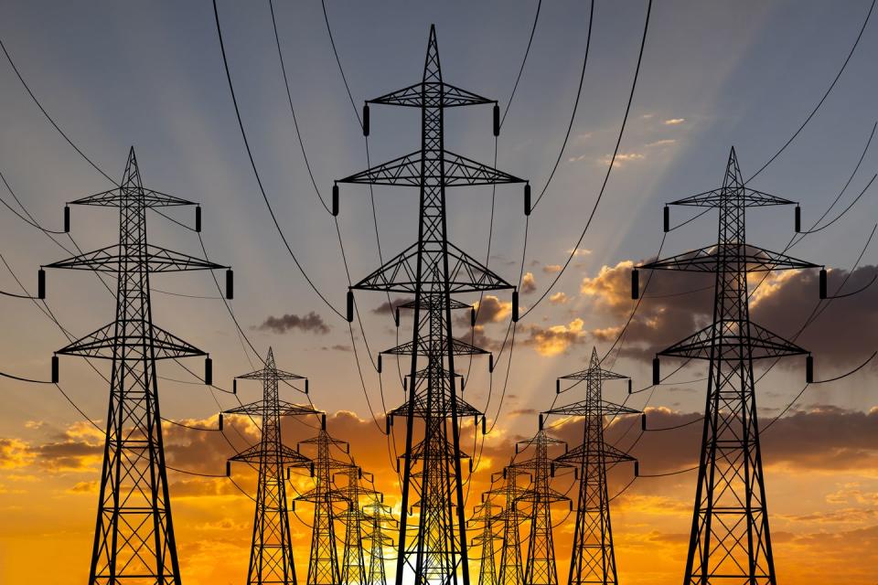 high voltage towers at sunset background power lines against the sky