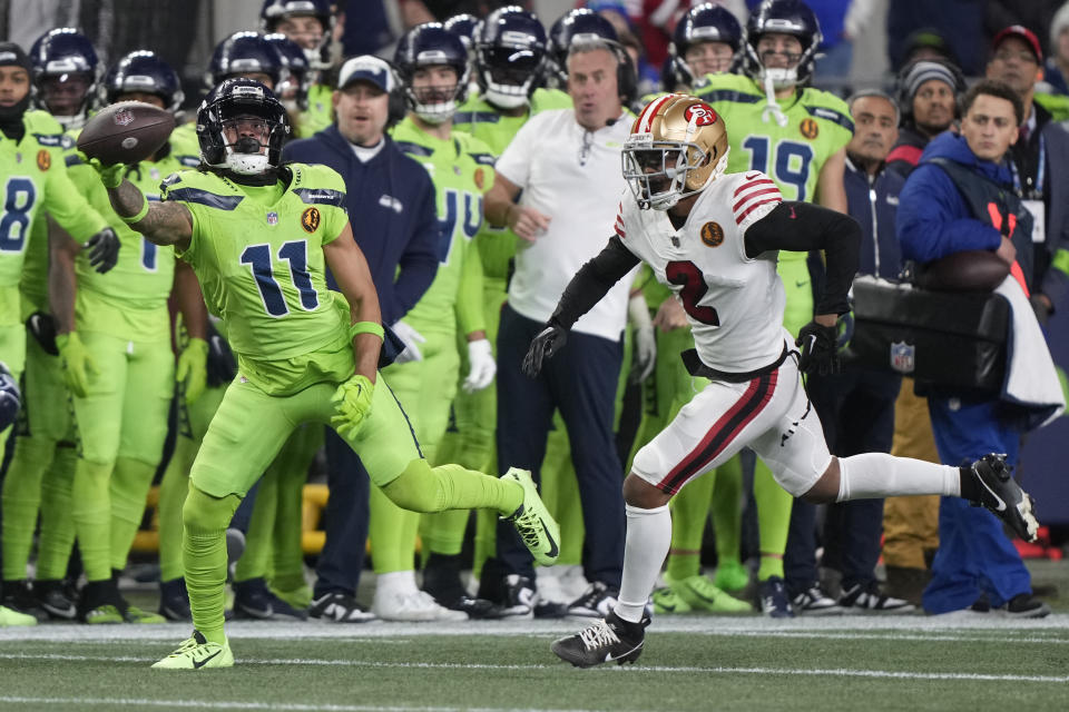 Seattle Seahawks wide receiver Jaxon Smith-Njigba (11), defended by San Francisco 49ers cornerback Deommodore Lenoir (2) makes a one handed catch during the second half of an NFL football game, Thursday, Nov. 23, 2023, in Seattle. (AP Photo/Stephen Brashear)