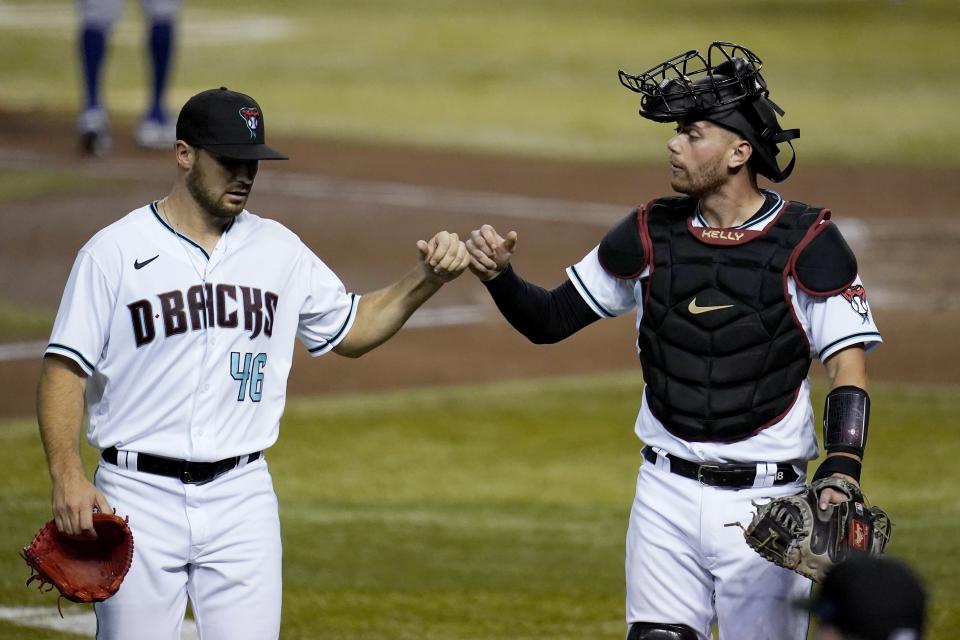 Arizona Diamondbacks pitcher Riley Smith (46) gets a fist bump from catcher Carson Kelly after Smith closed out the Texas Rangers in the fifth inning of a baseball game Tuesday, Sept. 22, 2020, in Phoenix. (AP Photo/Ross D. Franklin)