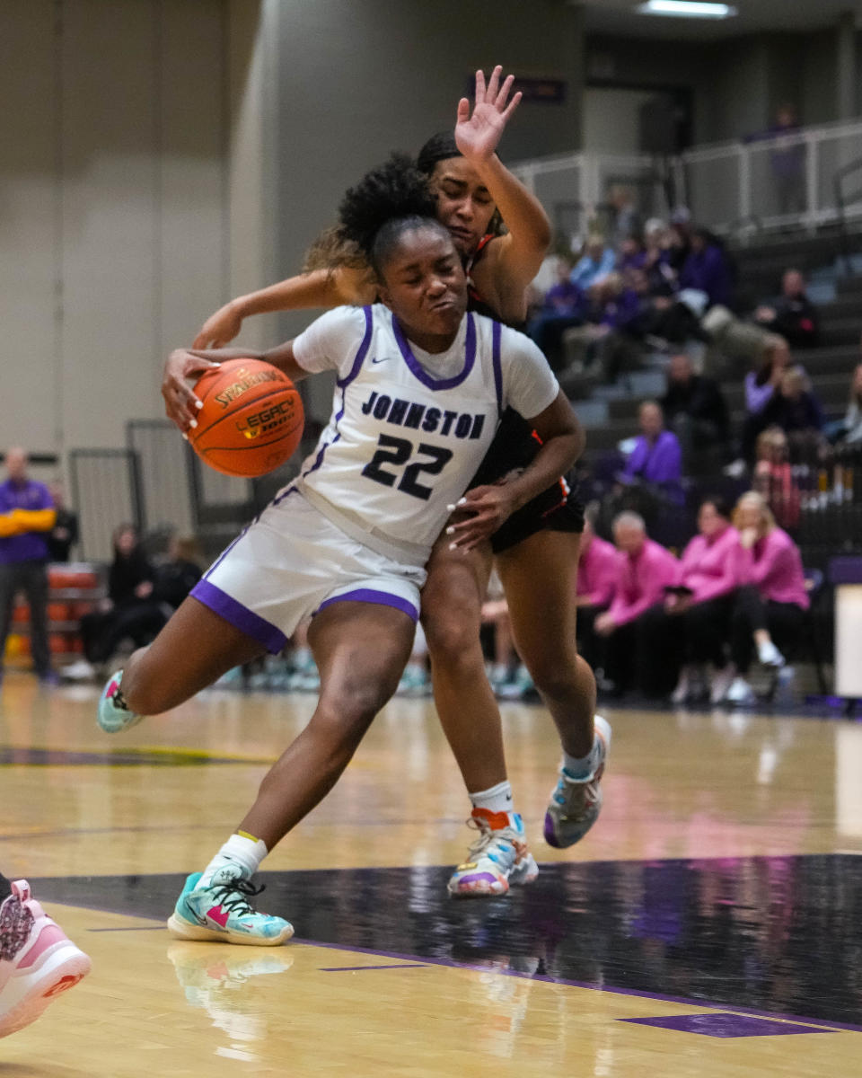 Johnston guard Aaliyah Riley (22) drives to the basket against Cedar Rapids Prairie guard DeLanee Seay during Monday's game at Johnston High School.