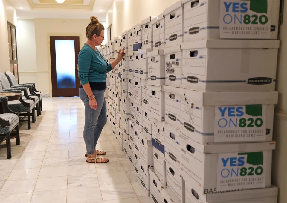 Amy Canton, director of Executive Legislative Services, checks the boxes Oklahomans for Sensible Marijuana Laws delivered Tuesday to the Office of the Secretary of State containing signed petitions calling for a statewide vote on legalizing marijuana.