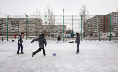 Children play football in the town of Aksu, north-eastern Kazakhstan, February 21, 2018. REUTERS/Shamil Zhumatov