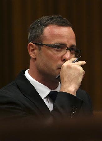 Olympic and Paralympic track star Oscar Pistorius reacts as he sits in the dock during his trial for the murder of his girlfriend Reeva Steenkamp, at the North Gauteng High Court in Pretoria, March 17, 2014. REUTERS/Siphiwe Sibeko