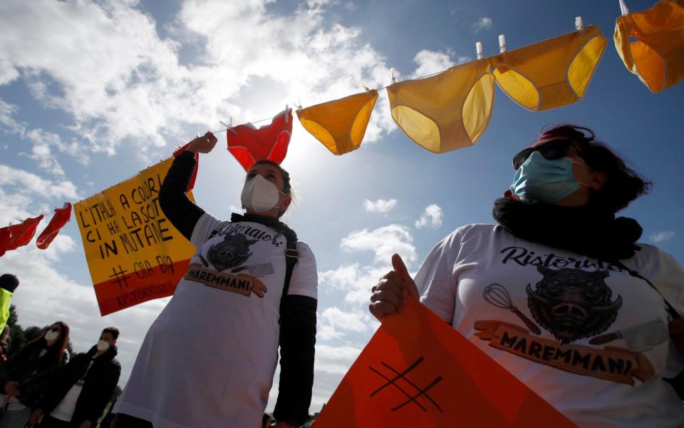 Restaurant owners hang coloured underwear during a protest against restriction measures to curb the spread of Covid-19 - AP Photo/Alessandra Tarantino