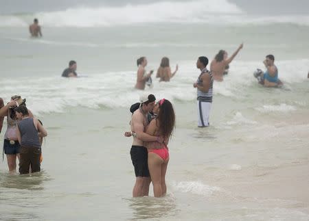 A couple kisses as they stand on the beach water during spring break festivities in Panama City Beach, Florida March 12, 2015. REUTERS/Michael Spooneybarger
