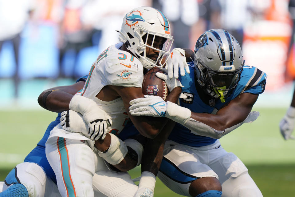 Carolina Panthers defensive tackle Derrick Brown and linebacker Brian Burns tackle Miami Dolphins running back Raheem Mostert (31) during the second half of an NFL football game, Sunday, Oct. 15, 2023, in Miami Gardens, Fla. (AP Photo/Wilfredo Lee)