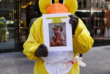 A man dressed in a duck costume stands with flyers opposed to U.S. Republican presidential candidate Donald Trump outside of Trump Tower in New York April 13, 2016. REUTERS/Shannon Stapleton