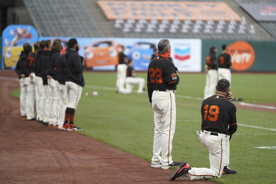 San Francisco Giants manager Gabe Kapler, right, kneels during the national anthem before a baseball game between the Giants and the San Diego Padres in San Francisco, Saturday, Sept. 26, 2020. (AP Photo/Eric Risberg)