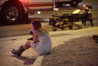 FILE - A woman sits on a curb on Oct. 2, 2017, at the scene of a shooting outside a music festival on Oct. 1 that killed 58 people and injured hundreds on the Las Vegas Strip. A new documentary, “11 Minutes,” is an inside account of the 2017 massacre at a country music concert in Las Vegas. More than three hours long, the four-part documentary debuts on the Paramount+ streaming service Tuesday. (AP Photo/John Locher, File)