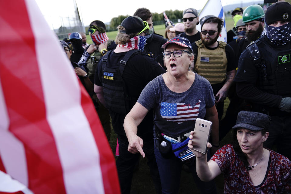 A right-wing demonstrator, center, yells at a counter protester to leave a rally by members of the Proud Boys and other right-wing demonstrators on Saturday, Sept. 26, 2020, in Portland, Ore. (AP Photo/John Locher)