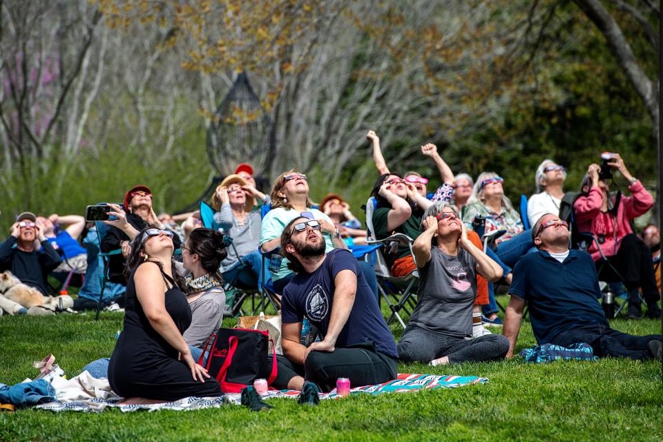 People take in the solar eclipse at the NC Arboretum, April 8, 2024, in Asheville.