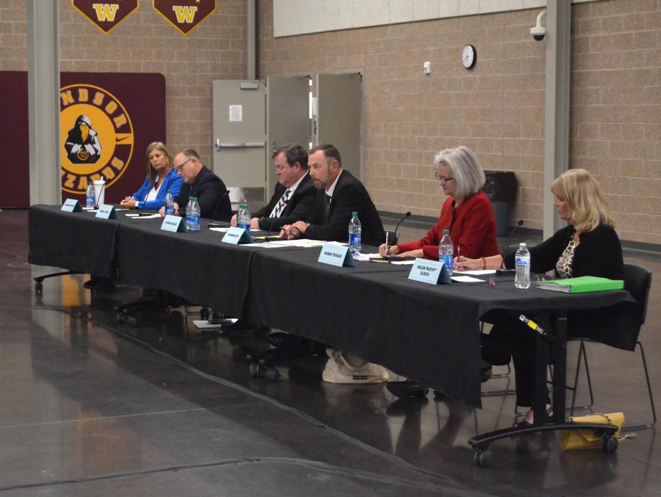 Candidates for the Weld RE-4 School District Board of Education jot down notes while waiting for their turn to speak during a "Meet the Candidates Night" on Tuesday at Windsor High School.