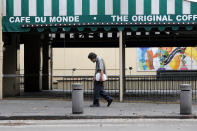 A man walks past a closed Cafe Du Monde, in the French Quarter of New Orleans, normally bustling with tourists, but now nearly completely deserted due to the new coronavirus pandemic, Friday, March 27, 2020. While rich in history and culture, New Orleans is economically poor, and the people here are not necessarily well-positioned to weather this latest storm. (AP Photo/Gerald Herbert)