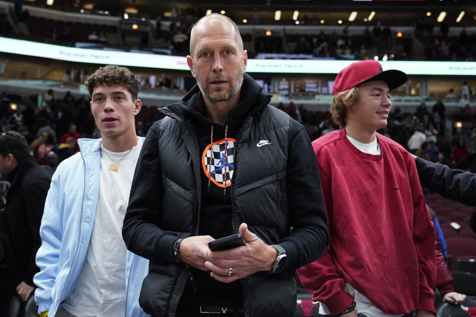 United States men's national soccer team head coach Gregg Berhalter, center, looks at a camera after the Chicago Bulls defeated the Dallas Mavericks in an NBA basketball game in Chicago, Saturday, Dec. 10, 2022. (AP Photo/Nam Y. Huh)