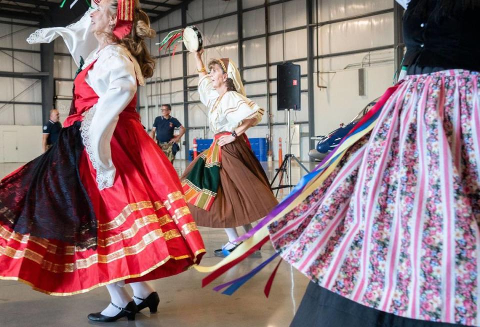 Sue Bonnici-Coleman, center, spins along with other members of the Balliamo Italian dance troupe as part of a greeting for the Frecce Tricolori jet team at Mather Airport near Rancho Cordova on Tuesday. The Italian air force team is slated to perform in this weekend’s California Capital Airshow. “What a thrill to see the pilots,” she said.