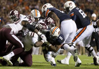 Texas A&M defense pulls down Auburn running back Roc Thomas (9) during the second half of an NCAA college football game Saturday, Nov. 8, 2014, in Auburn, Ala. (AP Photo/Brynn Anderson)